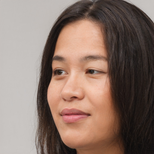Joyful asian young-adult female with long  brown hair and brown eyes