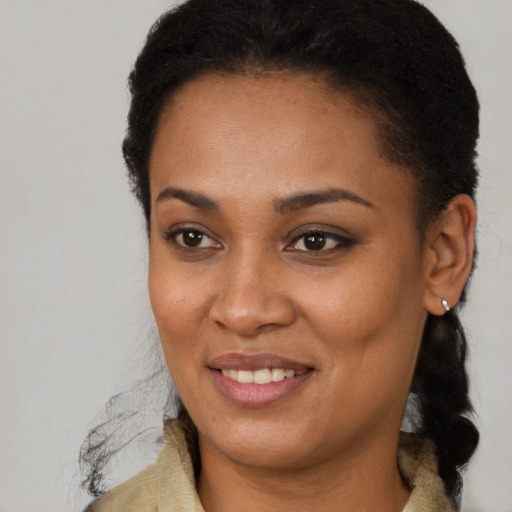 Joyful black young-adult female with long  brown hair and brown eyes