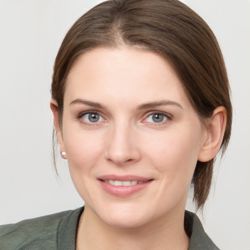 Joyful white young-adult female with medium  brown hair and grey eyes