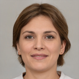 Joyful white adult female with medium  brown hair and brown eyes