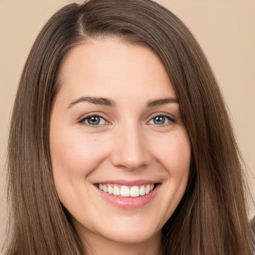 Joyful white young-adult female with long  brown hair and brown eyes