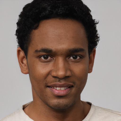 Joyful black young-adult male with short  black hair and brown eyes