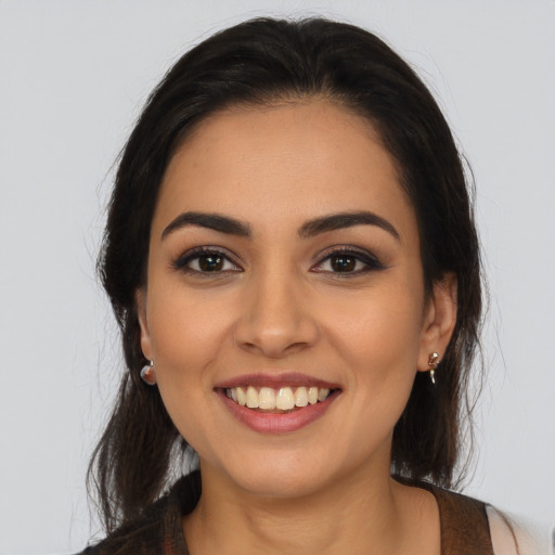 Joyful latino young-adult female with long  brown hair and brown eyes