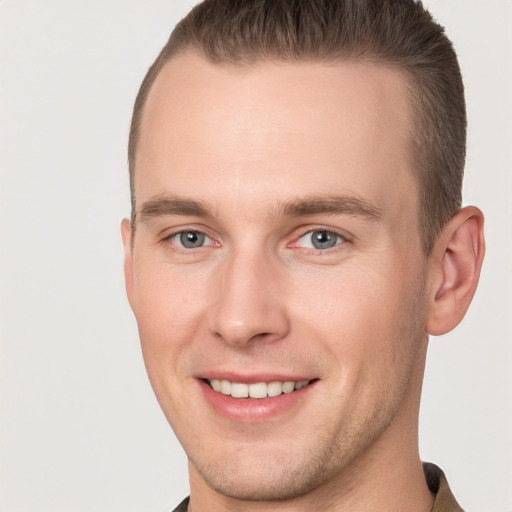 Joyful white young-adult male with short  brown hair and grey eyes