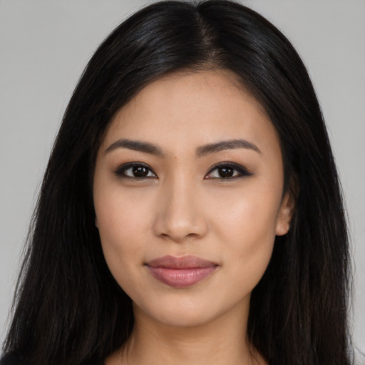 Joyful latino young-adult female with long  black hair and brown eyes