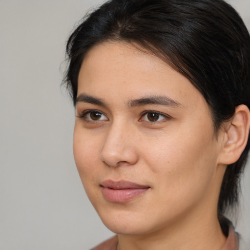 Joyful latino young-adult female with medium  brown hair and brown eyes