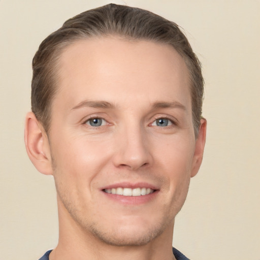 Joyful white young-adult male with short  brown hair and grey eyes