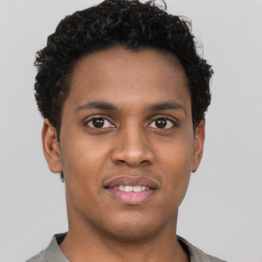 Joyful black young-adult male with short  brown hair and brown eyes