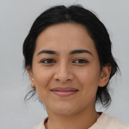 Joyful latino young-adult female with medium  brown hair and brown eyes