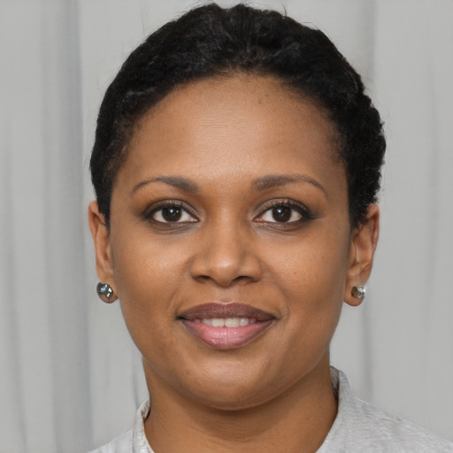 Joyful black young-adult female with short  brown hair and brown eyes
