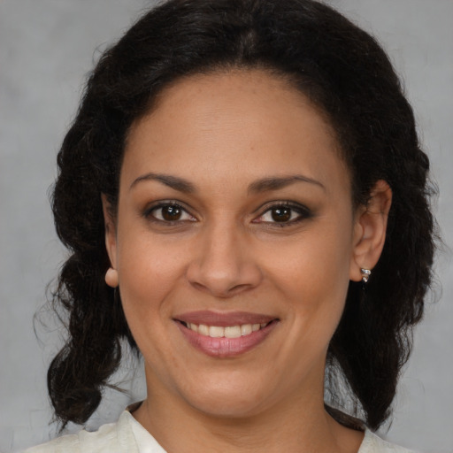 Joyful latino adult female with medium  brown hair and brown eyes