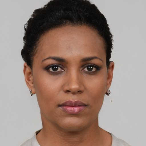 Joyful black young-adult female with short  black hair and brown eyes