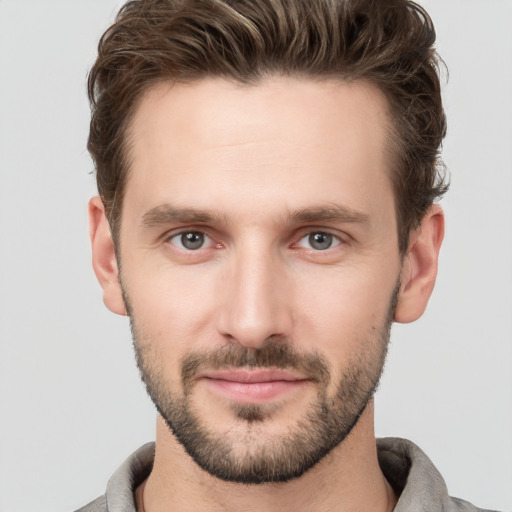 Joyful white young-adult male with short  brown hair and grey eyes