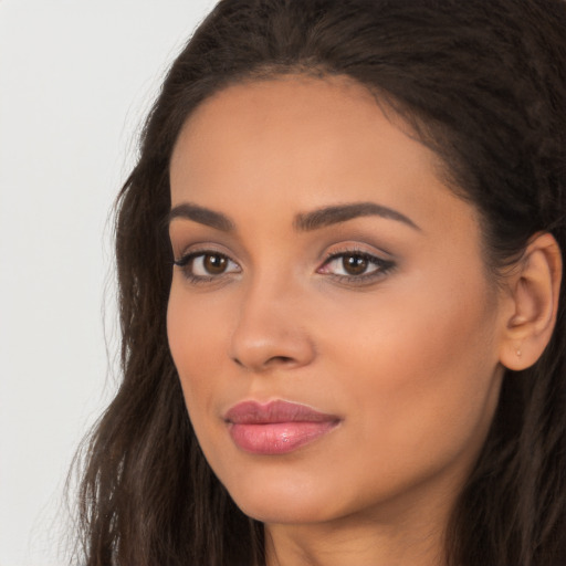 Joyful latino young-adult female with long  brown hair and brown eyes