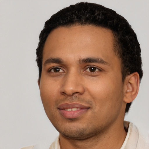 Joyful latino young-adult male with short  black hair and brown eyes