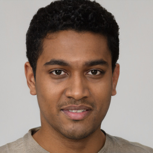 Joyful black young-adult male with short  black hair and brown eyes