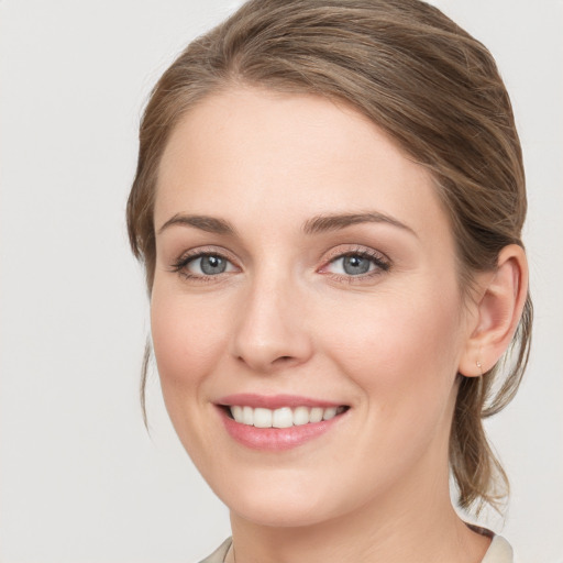 Joyful white young-adult female with medium  brown hair and blue eyes