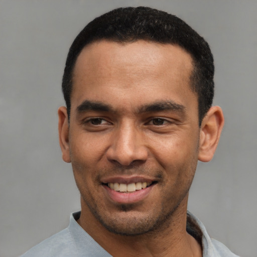 Joyful latino young-adult male with short  black hair and brown eyes