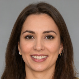 Joyful white young-adult female with long  brown hair and brown eyes