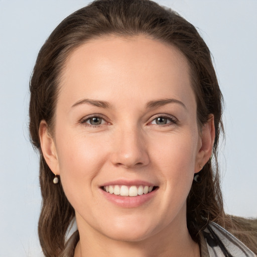 Joyful white young-adult female with long  brown hair and grey eyes