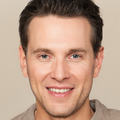 Joyful white adult male with short  brown hair and brown eyes