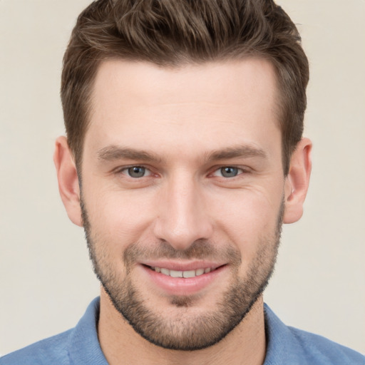 Joyful white young-adult male with short  brown hair and grey eyes