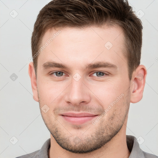 Joyful white young-adult male with short  brown hair and grey eyes