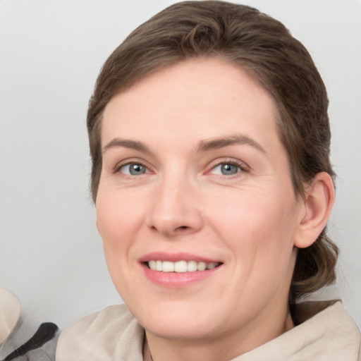 Joyful white adult female with medium  brown hair and green eyes