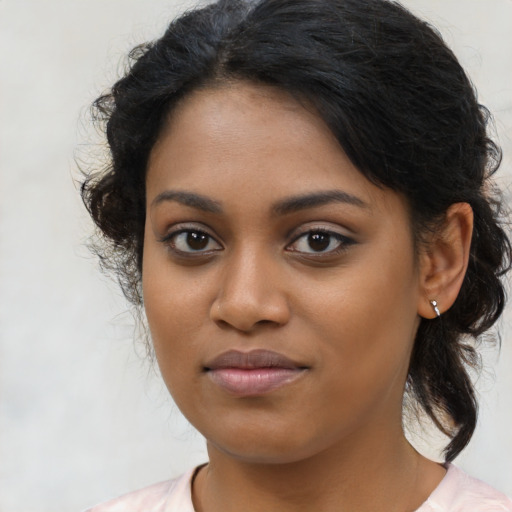 Joyful black young-adult female with medium  brown hair and brown eyes