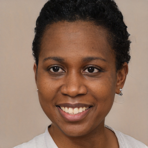 Joyful black young-adult female with short  brown hair and brown eyes