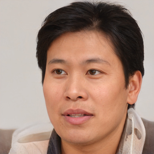 Joyful asian adult male with medium  brown hair and brown eyes