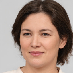 Joyful white adult female with medium  brown hair and brown eyes