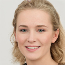 Joyful white young-adult female with long  brown hair and blue eyes