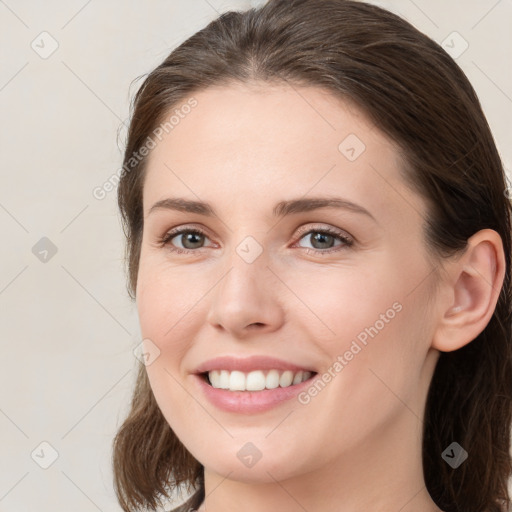 Joyful white young-adult female with medium  brown hair and grey eyes