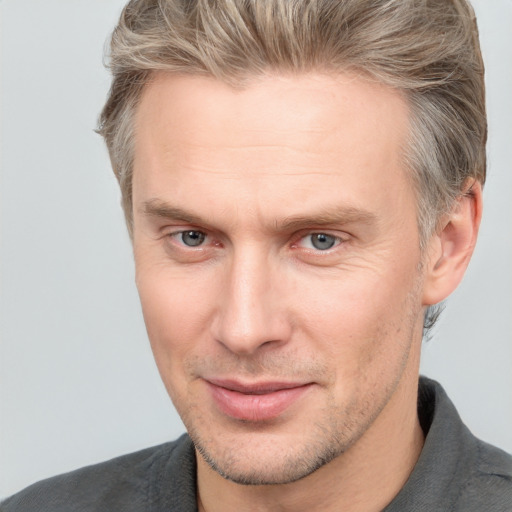 Joyful white adult male with short  brown hair and grey eyes