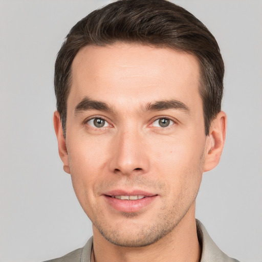 Joyful white young-adult male with short  brown hair and grey eyes