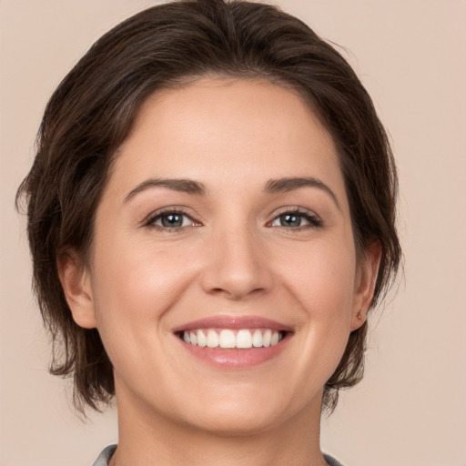 Joyful white young-adult female with medium  brown hair and brown eyes