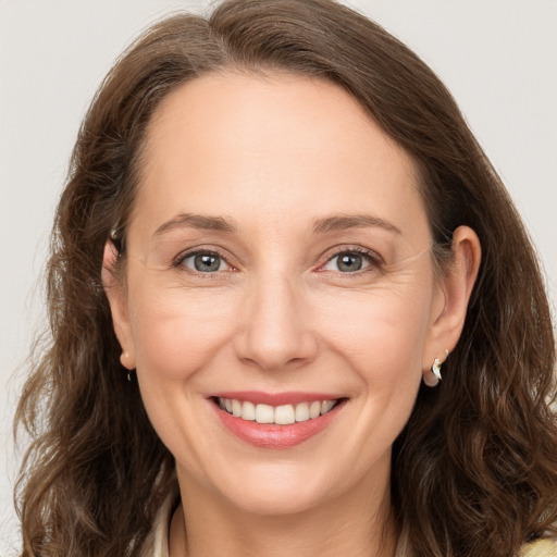 Joyful white adult female with long  brown hair and brown eyes