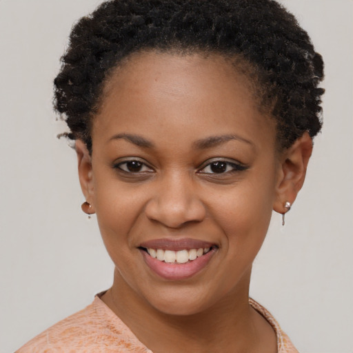 Joyful black young-adult female with short  brown hair and brown eyes