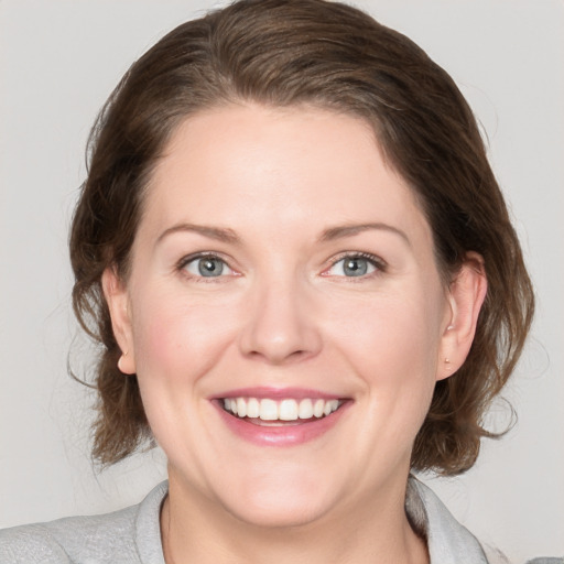 Joyful white young-adult female with medium  brown hair and blue eyes