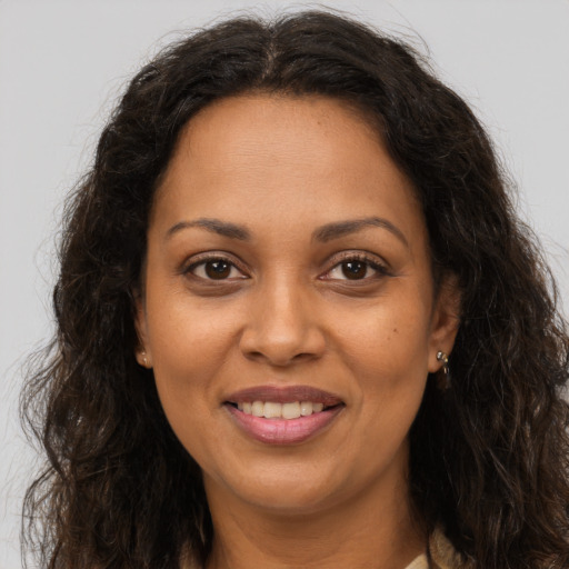 Joyful black adult female with long  brown hair and brown eyes