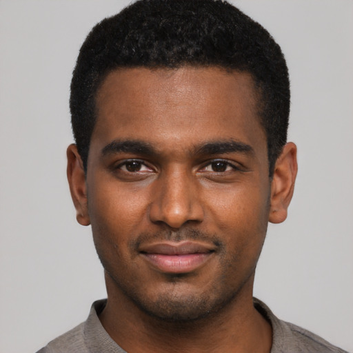 Joyful black young-adult male with short  black hair and brown eyes