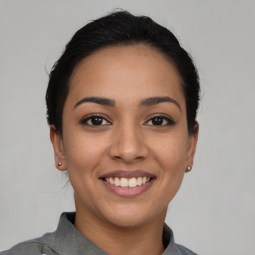 Joyful latino young-adult female with short  black hair and brown eyes