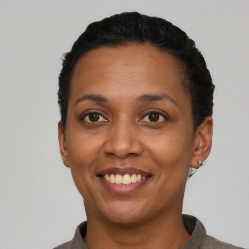 Joyful black adult female with short  black hair and brown eyes