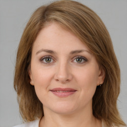 Joyful white young-adult female with medium  brown hair and green eyes