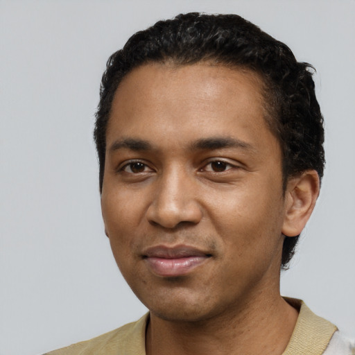Joyful black young-adult male with short  black hair and brown eyes