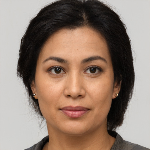 Joyful latino young-adult female with medium  brown hair and brown eyes