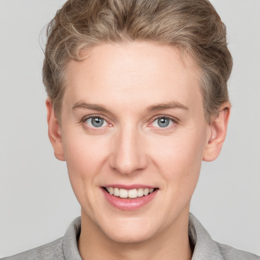 Joyful white young-adult female with short  brown hair and grey eyes