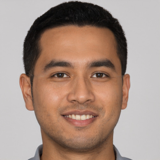 Joyful latino young-adult male with short  brown hair and brown eyes