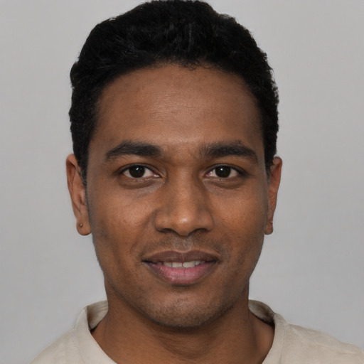 Joyful black young-adult male with short  black hair and brown eyes